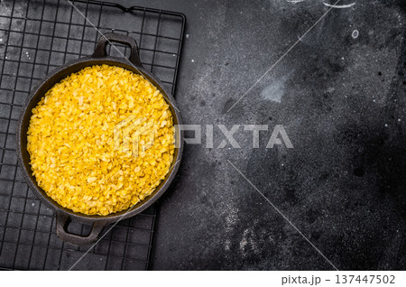 Healthy raw dry Millet flakes for porridge and muesli. black background. top view Healthy raw dry Millet flakes for porridge and muesli. black background. top view 137447502