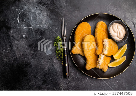 Crispy fried cod Fish sticks on plate. black background. top view Crispy fried cod Fish sticks on plate. black background. top view 137447509