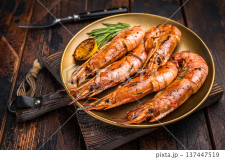Grilled red Argentine shrimps, Prawns Langostino Austral on a plate with herbs. wooden background. top view 137447519