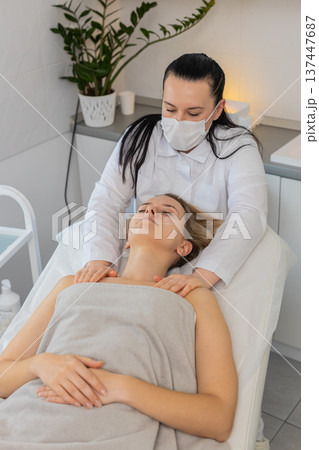 Beautician neck and jawline massage relaxing middle aged young woman in cosmetology clinic Beautician neck and jawline massage relaxing middle aged young woman in cosmetology clinic 137447687