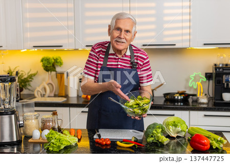 Senior old man teaching vegetable salad recipe in kitchen at home for healthy diet cooking tutorial 137447725