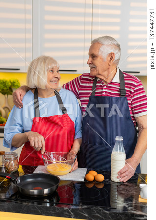 Senior old woman man cooking healthy omelet breakfast in home kitchen with cheerful elderly couple 137447731