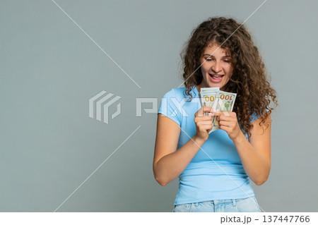 Woman hold dollar cash money smiling satisfied celebrating salary savings loan financial success joy 137447766