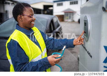 Woman charging electric car at self-service station 137447855