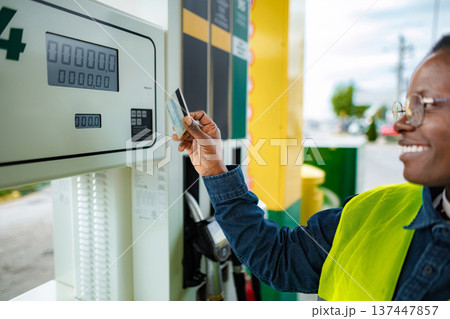 Smiling man paying fuel with credit card at gas station 137447857