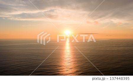 Golden hour sunset reflecting on ocean water Golden hour sunset reflecting on ocean water 137448395