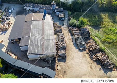 Aerial view of a sawmill factory uses renewable solar energy, with stacks of processed lumber and timber 137449460