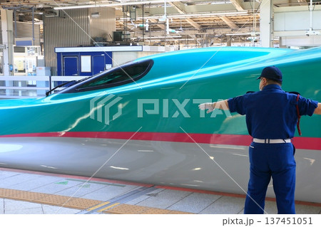 出発する東北新幹線のホームを規制するガードマン 137451051