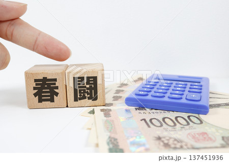 春闘を表す紙幣と文字ブロックの労働問題イメージ。 春闘を表す紙幣と文字ブロックの労働問題イメージ。 137451936