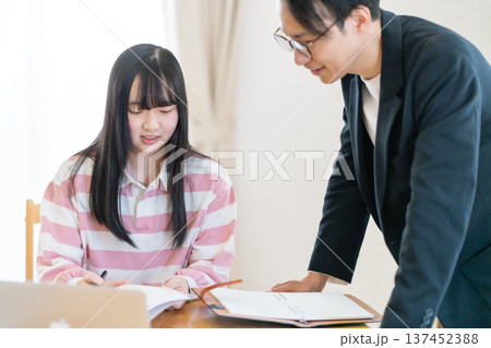 家庭教師からマンツーマンで試験対策を学ぶ高校生 家庭教師からマンツーマンで試験対策を学ぶ高校生 137452388