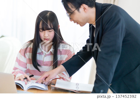 家庭教師からマンツーマンで試験対策を学ぶ高校生 家庭教師からマンツーマンで試験対策を学ぶ高校生 137452392