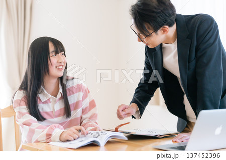 家庭教師からマンツーマンで試験対策を学ぶ高校生 137452396