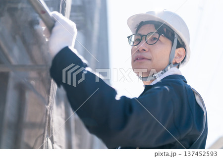 建設現場で足場の解体・組立作業を行う男性職人 建設現場で足場の解体・組立作業を行う男性職人 137452593