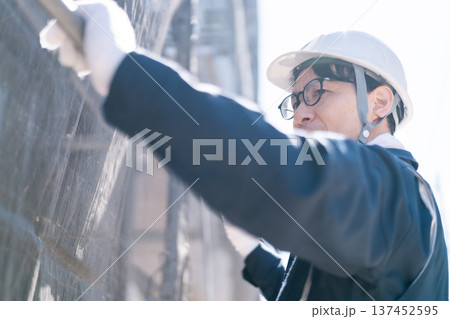 建設現場で足場の解体・組立作業を行う男性職人 建設現場で足場の解体・組立作業を行う男性職人 137452595