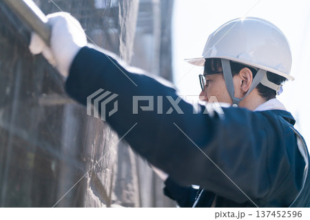 建設現場で足場の解体・組立作業を行う男性職人 建設現場で足場の解体・組立作業を行う男性職人 137452596