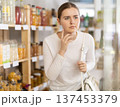 Young woman near the shelves in the supermarket 137453379