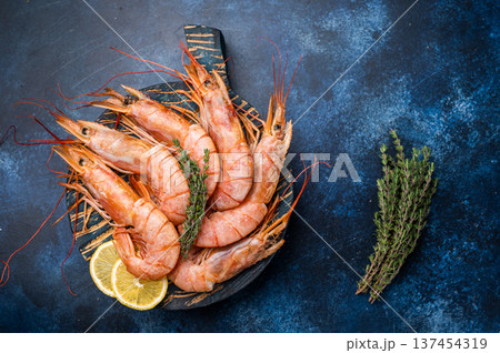 Ready for cooking Red Argentine shrimps, raw Prawns Langostino Austral on wooden board. blue background. top view 137454319