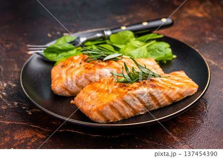 Grilled salmon fillet with spinach, fish steak in a plate. brown background. top view 137454390