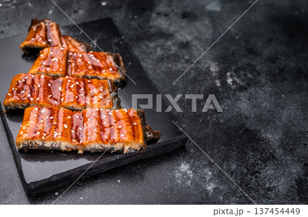 Unagi kabayaki eel, japanese grilled fish fillet with sauce. black background. top view 137454449