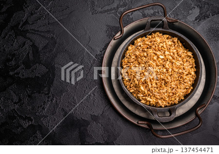 Crispy Fried dried Onion Bits. black background. top view Crispy Fried dried Onion Bits. black background. top view 137454471