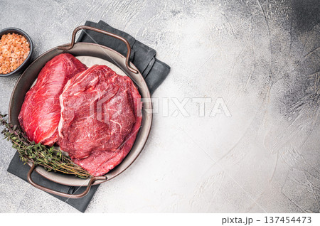 Uncooked beef cheeks, raw meat in steel tray. grey background. top view Uncooked beef cheeks, raw meat in steel tray. grey background. top view 137454473