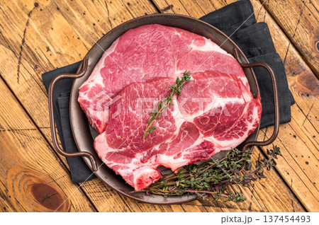 Uncooked pork tender steak, raw sliced neck meat with thyme. wooden background. top view Uncooked pork tender steak, raw sliced neck meat with thyme. wooden background. top view 137454493