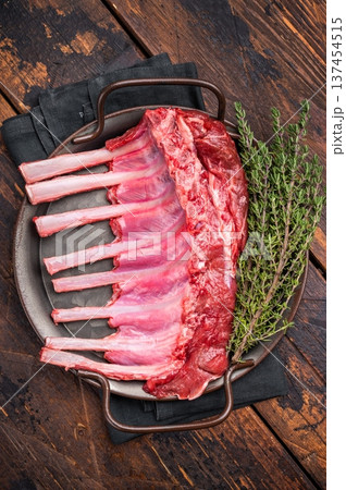 Fresh rack of lamb, raw mutton meat for chops steaks on steel tray. wooden background. top view Fresh rack of lamb, raw mutton meat for chops steaks on steel tray. wooden background. top view 137454515