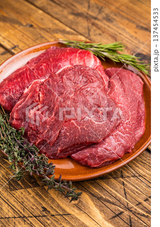 Traditional German beef cheeks, raw meat in plate. wooden background. top view Traditional German beef cheeks, raw meat in plate. wooden background. top view 137454533