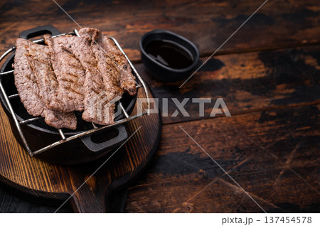 Flavorful yakiniku with juicy wagyu beef slices cooked right at the table. wooden background. top view Flavorful yakiniku with juicy wagyu beef slices cooked right at the table. wooden background. top view 137454578