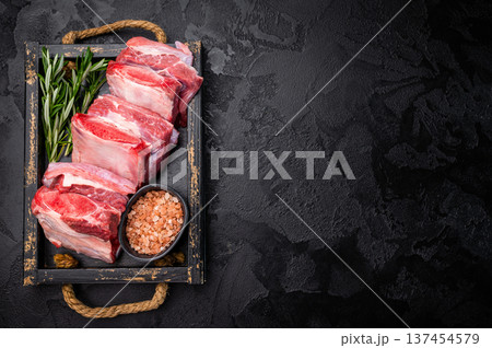 Raw Veal Short Rib, fresh beef meat with bone and herbs for cooking . black background. top view Raw Veal Short Rib, fresh beef meat with bone and herbs for cooking . black background. top view 137454579