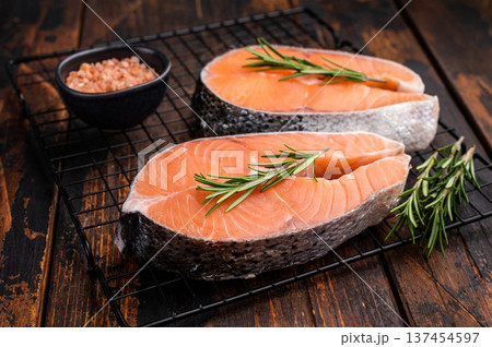 Vibrant raw salmon steak, showcasing its rich color and texture, ideal for sushi or sashimi enthusiasts seeking quality ingredients. wooden background. top view 137454597