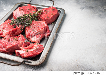 Fresh Raw beef tenderloin steaks with herbs and spices, marble meat ready for roast. grey background. top view Fresh Raw beef tenderloin steaks with herbs and spices, marble meat ready for roast. grey background. top view 137454606