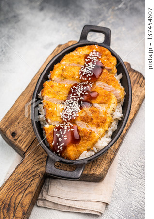 Katsu Crispy cutlet, perfectly breaded and golden brown, served with a side of rice and tangy sauce. A delicious Japanese classic that's hard to resist!. grey background. top view Katsu Crispy cutlet, perfectly breaded and golden brown, served with a side of rice and tangy sauce. A delicious Japanese classic that's hard to resist!. grey background. top view 137454607