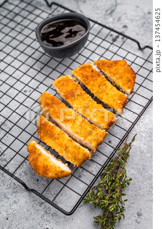 Tender chicken cutlet katsu, coated in crunchy breadcrumbs and fried to perfection. Ideal for a satisfying meal or as a topping for rice. grey background. top view 137454625