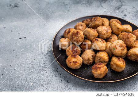 Savory meatballs, meat dumplings garnished with fresh herbs. A delightful addition to any meal, bringing warmth and satisfaction to the table. grey background. top view 137454639