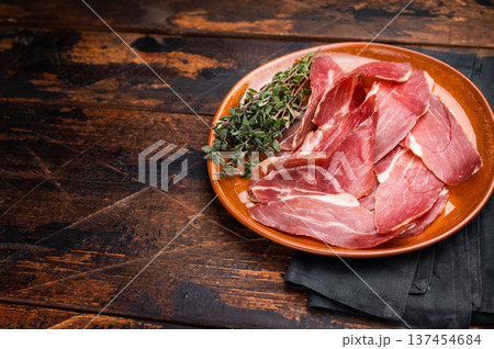 Tyrolean raw ham Speck, Italian sliced cured pork meat. wooden background. top view Tyrolean raw ham Speck, Italian sliced cured pork meat. wooden background. top view 137454684