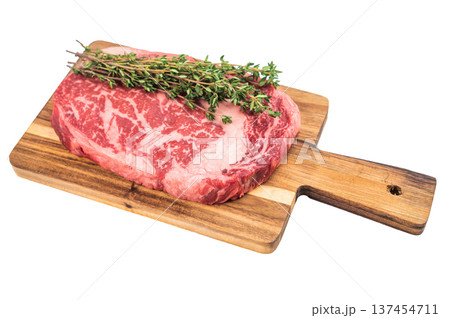 Raw marbled ribeye steak, rib fillet beef cut with rich fat marbling on rustic wooden board, fresh uncooked meat with copy space Raw marbled ribeye steak, rib fillet beef cut with rich fat marbling on rustic wooden board, fresh uncooked meat with copy space 137454711