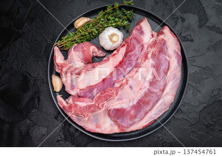 Fresh raw lamb meat belly or breast with herbs and garlic on dark background uncooked ingredient for roasting bbq and slow cooking 137454761