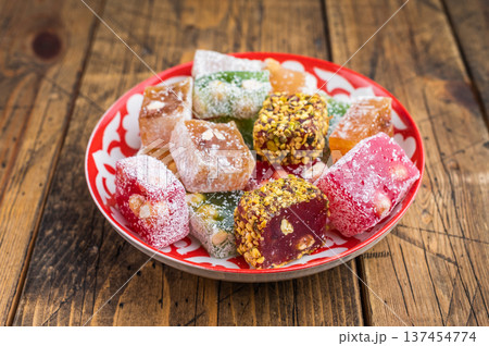 Mixed lokum candy cubesin eastern plate on wooden background. Handmade confectionery with modern rustic style. 137454774