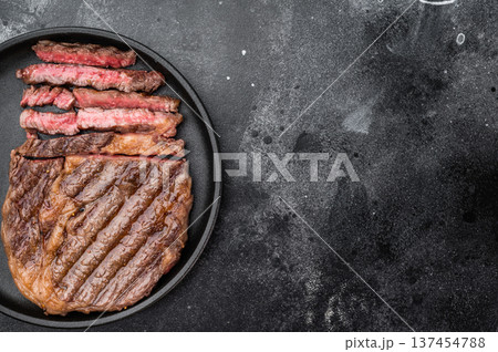 Fried rib eye steak entrecote style sliced medium rare. Grilled beef with rich marbling in plate with rosemary and thyme. Fried rib eye steak entrecote style sliced medium rare. Grilled beef with rich marbling in plate with rosemary and thyme. 137454788