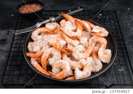 Boiled prawns frozen for storage served in minimal style. Seafood protein on black background, overhead composition. Boiled prawns frozen for storage served in minimal style. Seafood protein on black background, overhead composition. 137454927