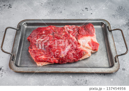 Raw beef brisket on metal tray with garlic and rosemary, top view cooking preparation scene with copy space 137454956