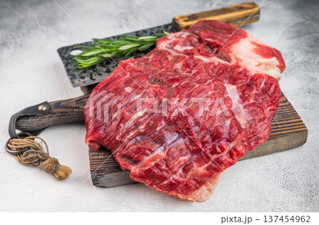 Raw beef brisket on wooden board with butcher tools, fresh uncooked meat cut ideal for barbecue, smoking and slow roasting 137454962