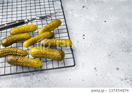 Crunchy pickled cucumbers, bursting with flavor, perfect for sandwiches, salads, or as a tangy snack. grey background Crunchy pickled cucumbers, bursting with flavor, perfect for sandwiches, salads, or as a tangy snack. grey background 137454974