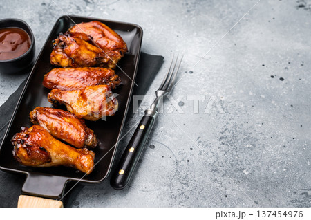 Juicy barbecue chicken wings, perfectly grilled and glazed, ideal for your next summer cookout or party. grey background. top view Juicy barbecue chicken wings, perfectly grilled and glazed, ideal for your next summer cookout or party. grey background. top view 137454976