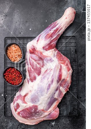 Fresh raw lamb shoulder, leg perfect for slow cooking or roasting to create a tender, flavorful meal. black background. top view Fresh raw lamb shoulder, leg perfect for slow cooking or roasting to create a tender, flavorful meal. black background. top view 137455017