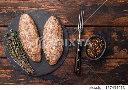 A platter of raw lula kebabs marinated in aromatic herbs, perfect for barbecuing or grilling at your next gathering. wooden background. top view 137455018