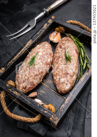Raw kebabs or kabaps on wooden tray, beautifully arranged and ready to be cooked for a delicious outdoor feast. black background. top view 137455021