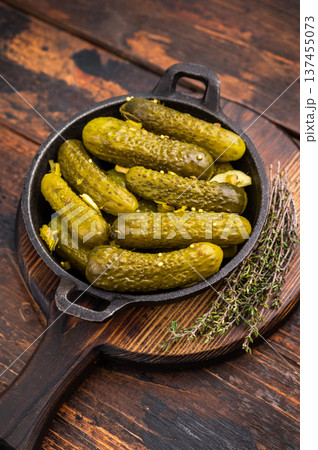 Artisan Pickled Gherkins, pickled cucumbers, beautifully arranged and ready to elevate your culinary creations with their bold taste. wooden background. top view 137455073