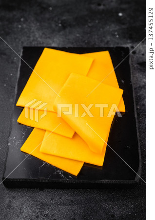 Cheddar cheese slices arranged on dark board top view dairy product texture and modern food background with copy space Cheddar cheese slices arranged on dark board top view dairy product texture and modern food background with copy space 137455129